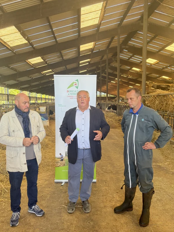 Trois intervenants devant la bannière de la Chambre d’agriculture, avec les vaches de la ferme du lycée en arrière-plan.