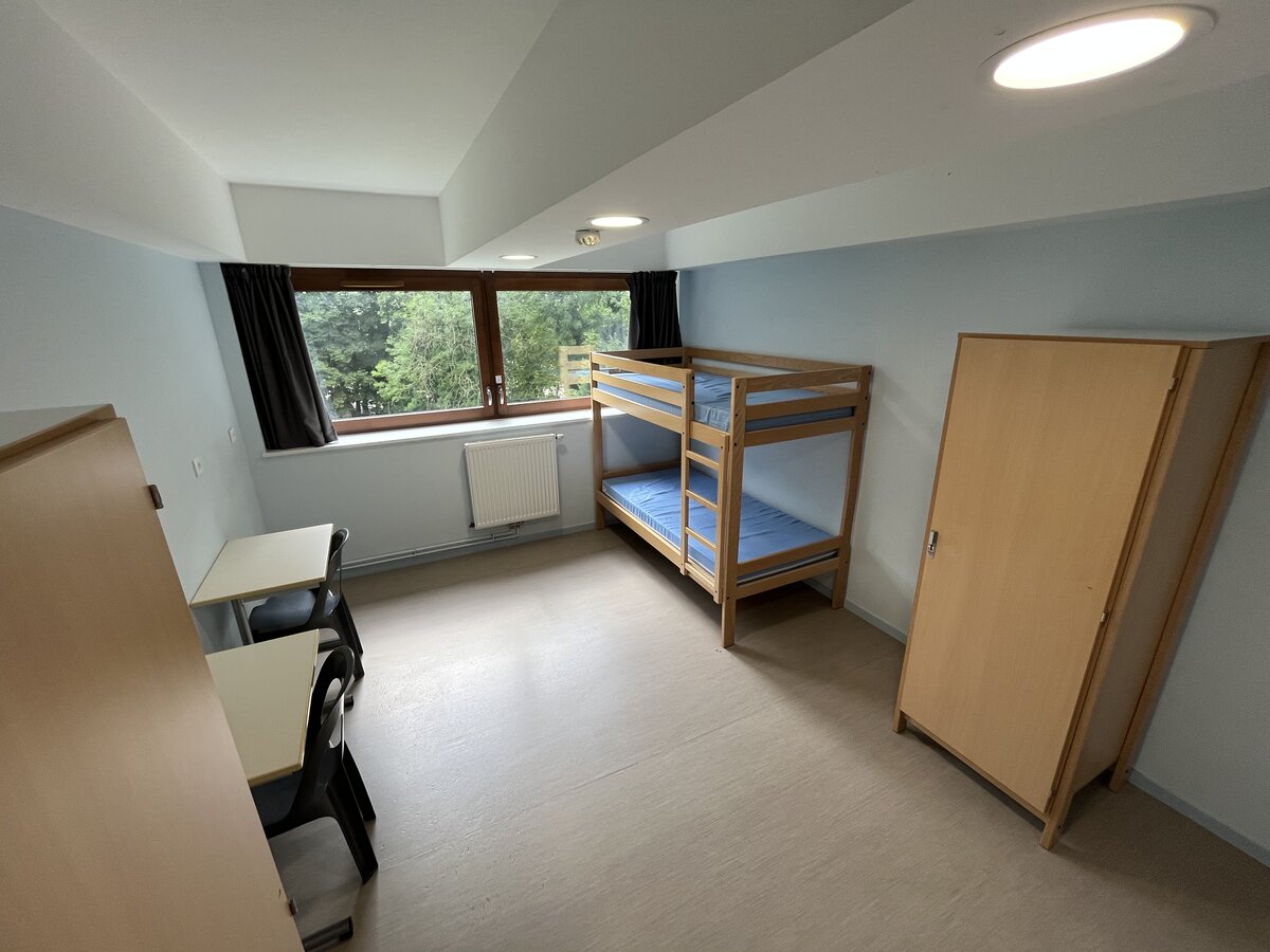 Chambre d'internat avec lit superposé donnant sur le parc du lycée